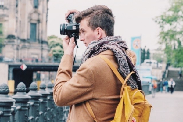 photo of recent graduate taking a photo with a camera