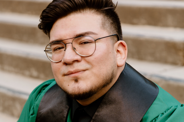 headshot of man in glasses sitting on steps