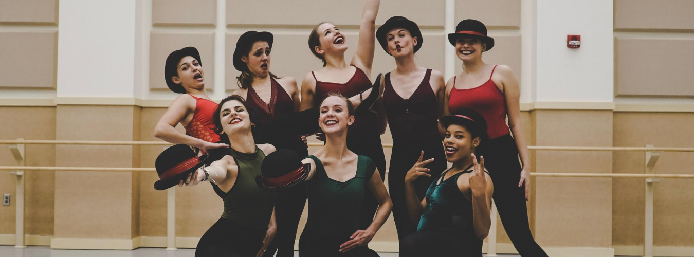 Group of students standing in the middle of a studio smiling and posing