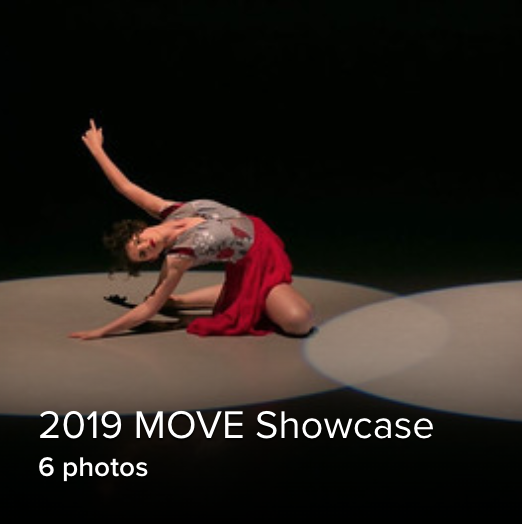 solo shot of a dancer in a red skirt sitting on the floor, reaching up in a spotlight