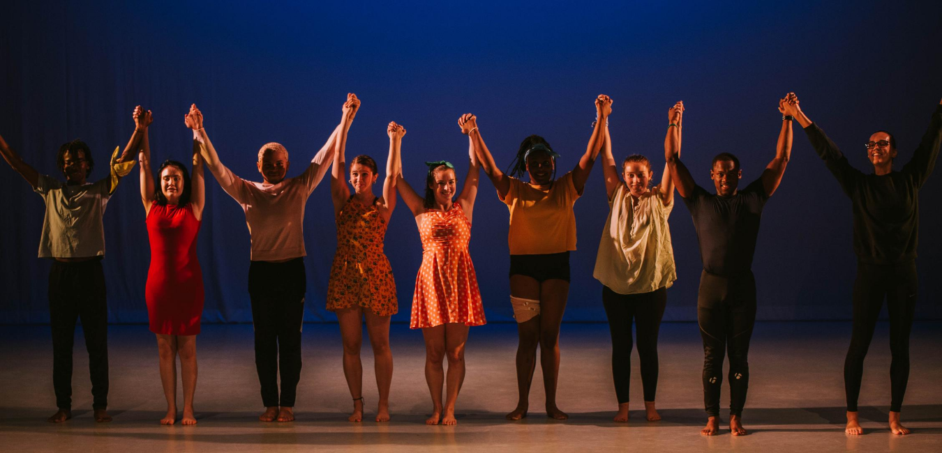 students holding hands getting ready to bow after a performance 