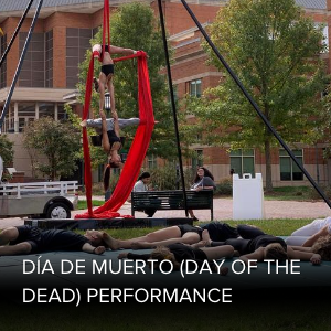 two students hanging from red silks 